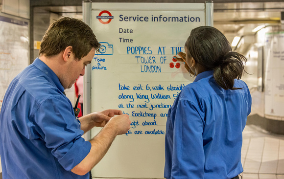 Staff at Bank tube station decorate the directions notice with poppies.