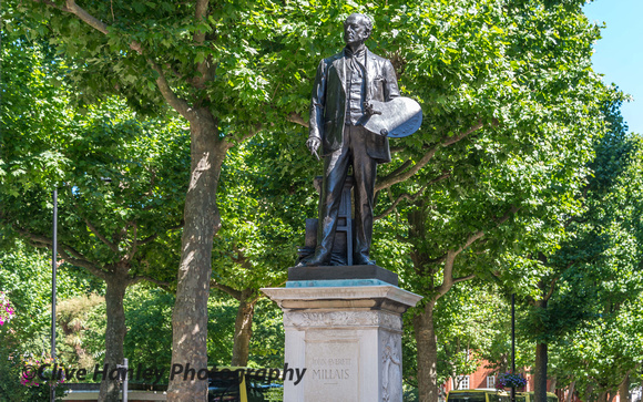 A statue of John Everett Millais sits outside.