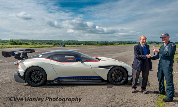 In exchange for a £5 note Wing Commander Mike Pollitt hands over the keys of the £1.8m Aston Martin Vulcan to the former A.V.Roe Test Pilot Tony Blackman