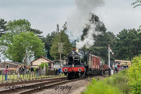 7812 Erlestoke Manor departs from Gotherington with a footplate crew member leaning out to catch the token.