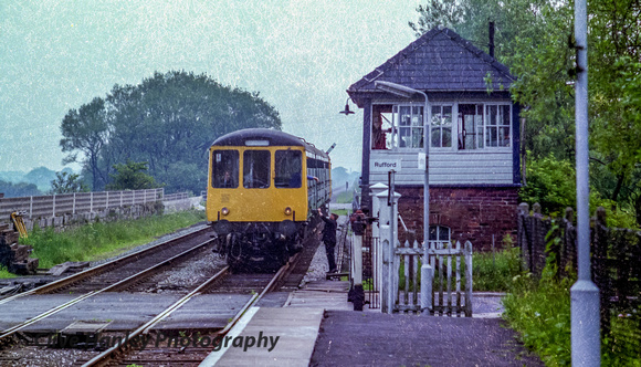 A DMU arrives at Rufford from Preston with the bobby collecting the single line token.