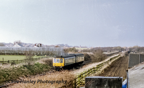 The two car DMU heads north towards Rufford and onwards to Preston. Rufford church can be seen centre.