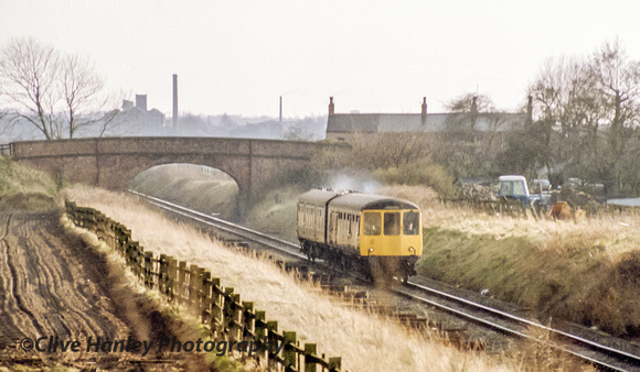 A 2 car DMU heads north from Burscough Junction. The track had only recently been singled and sleepers can be seen still lying on the track bed.