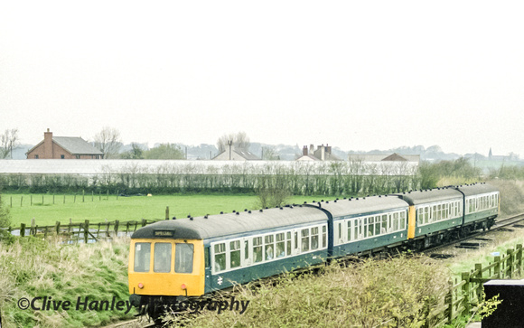 The special 4 car DMU heads north and appears full. Rufford church in shot - right.