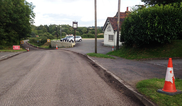 19/08/14 The road surface all the way down the hill has been stripped off.