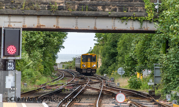 With a background of wind turbines off the coast 508104 approaches New Brighton station.
