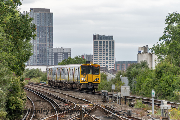 508126 approaching Sandhills station. Liverpool docks are to the right.